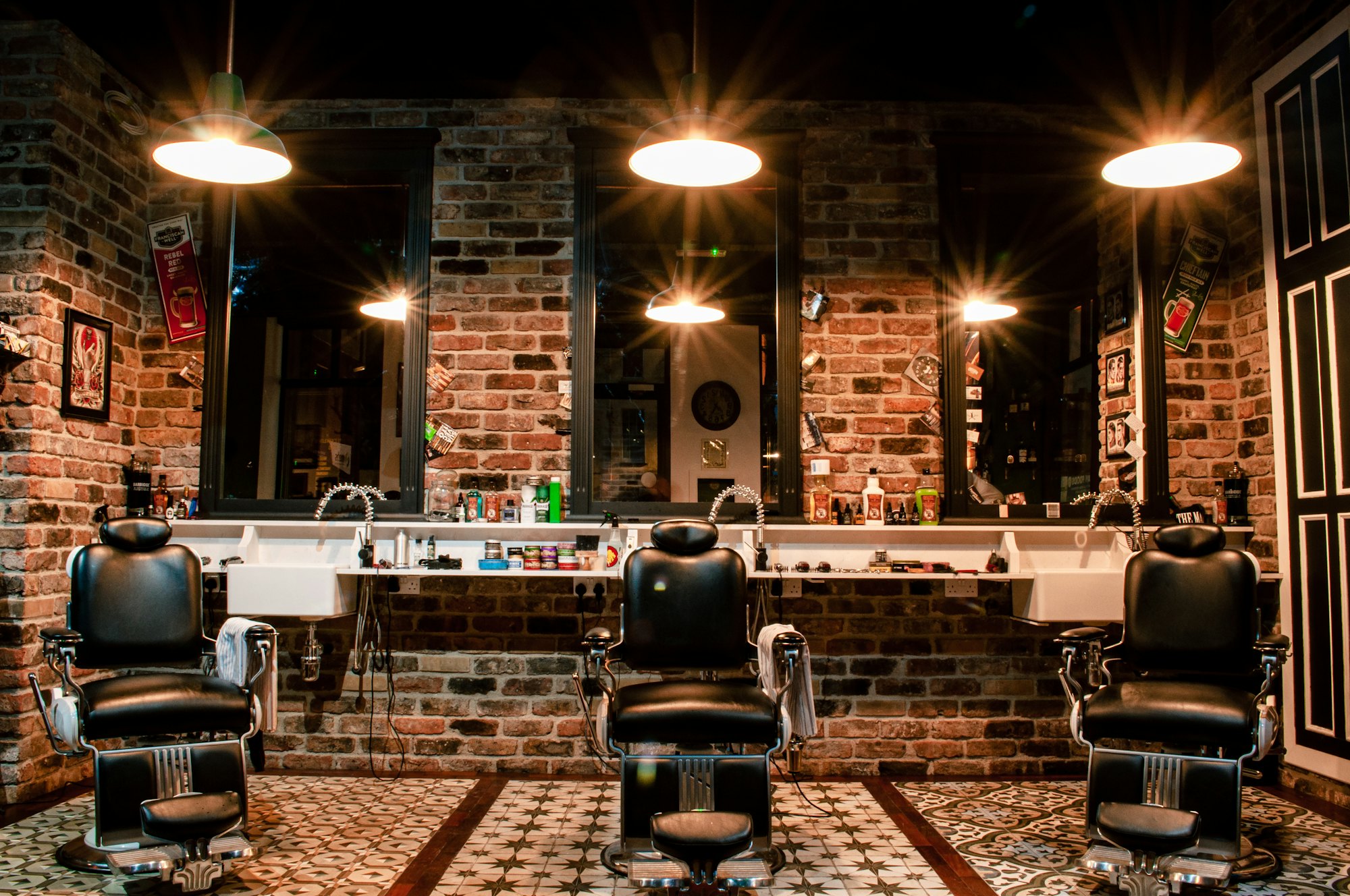 Interieur van een barbershop met leren stoelen en bakstenen muur